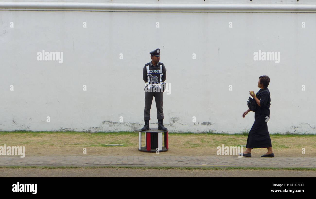Police Officer standing guard near the wall, Royal Palace, Bangkok Stock Photo