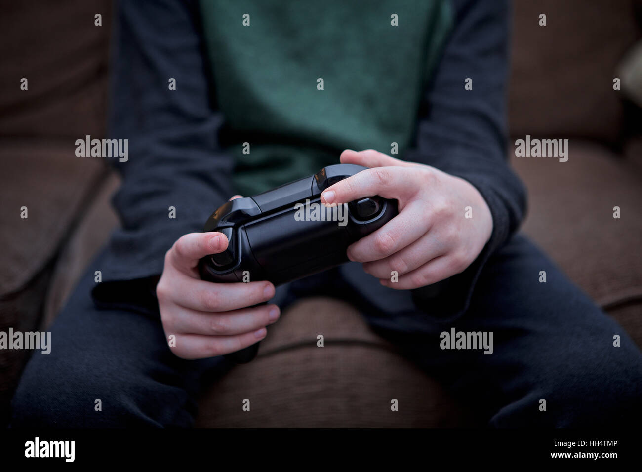 Close-up of a young boy holding video game controller. Stock Photo