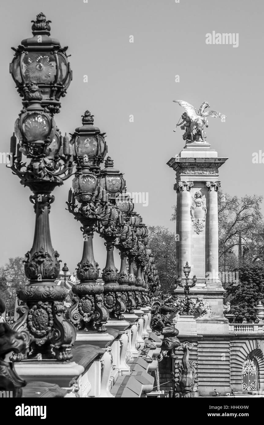 A black and white image of the ornate lamp posts on the Alexander lll bridge in Paris France. Stock Photo
