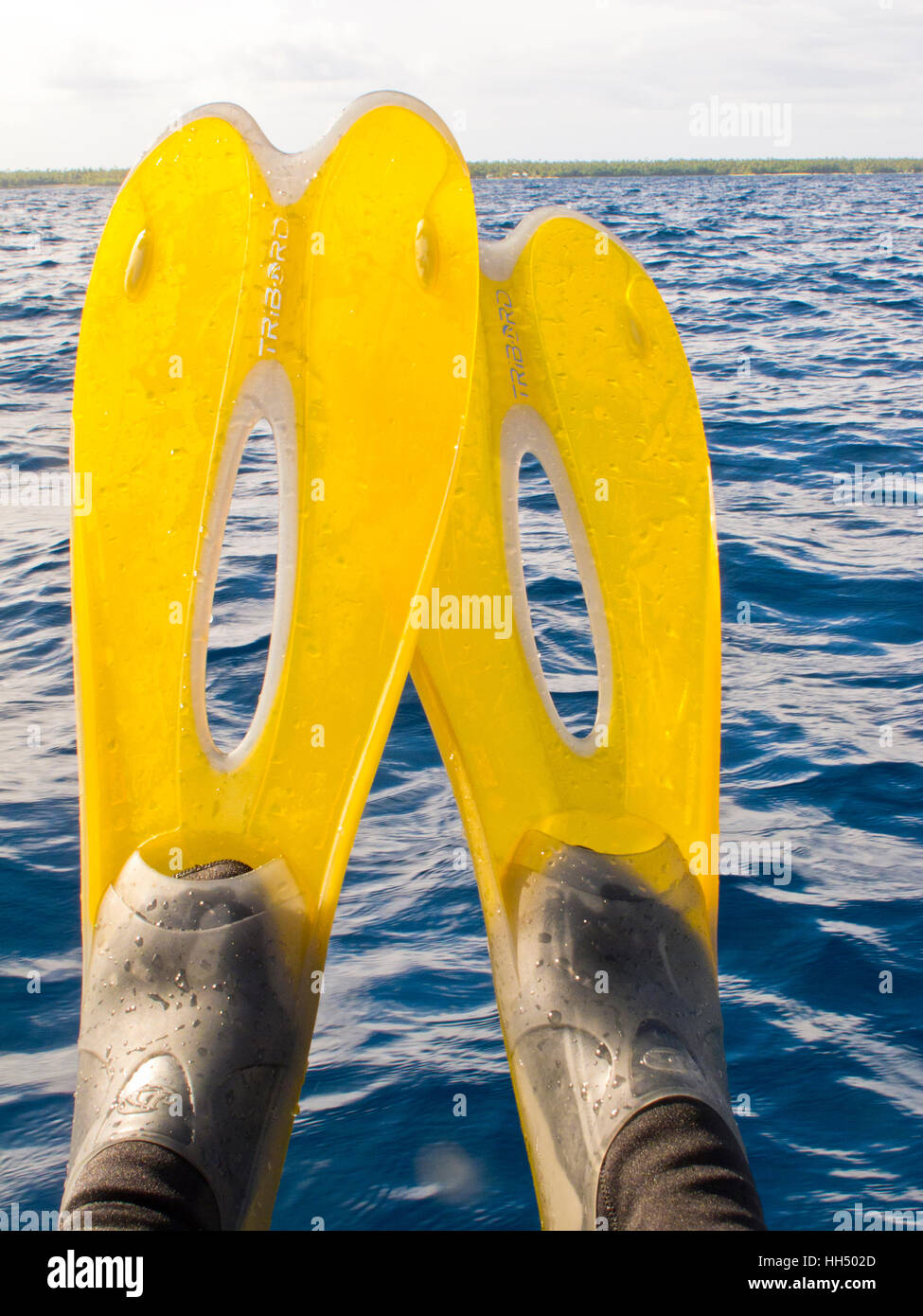 Person floating wearing flippers  Foa island. Haapai islands, Tonga. Polynesia Stock Photo
