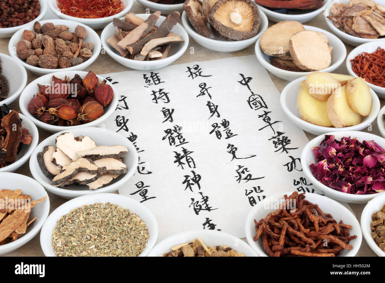 Chinese herb selection used in herbal medicine with calligraphy script, translation describes chinese herbal medicine as increasing the bodys ability  Stock Photo