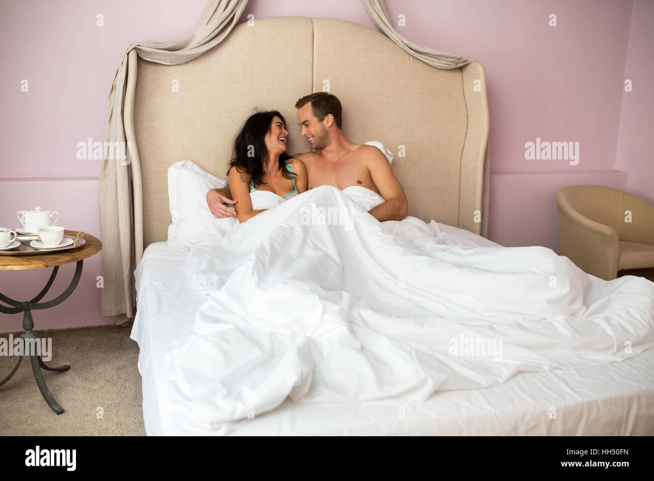 Couple in bed smiling. Stock Photo