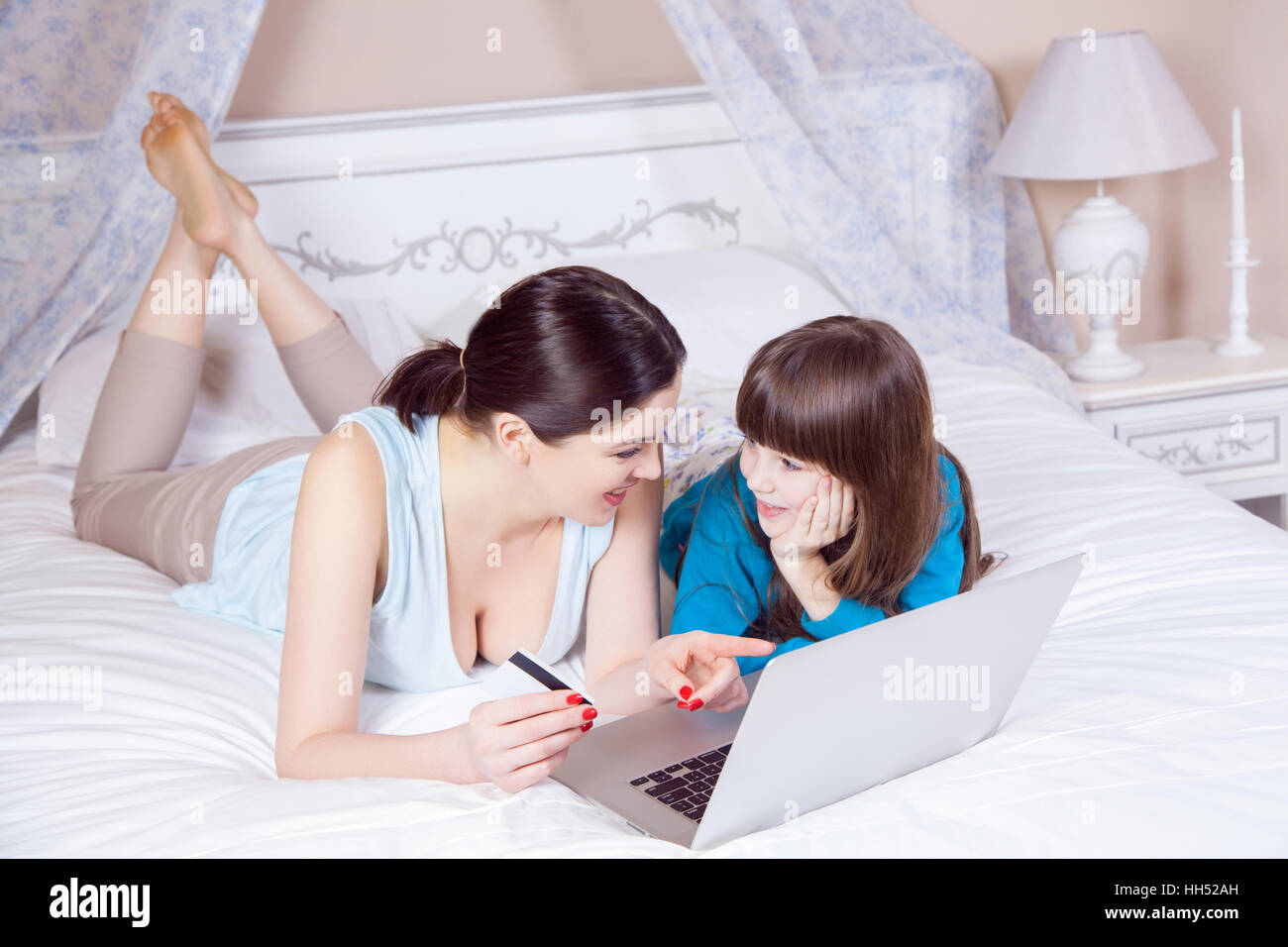 Happy mother and daughter do online shopping with laptop. Stock Photo