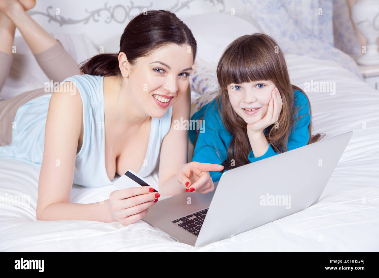 Happy mother and daughter do online shopping with laptop. Stock Photo