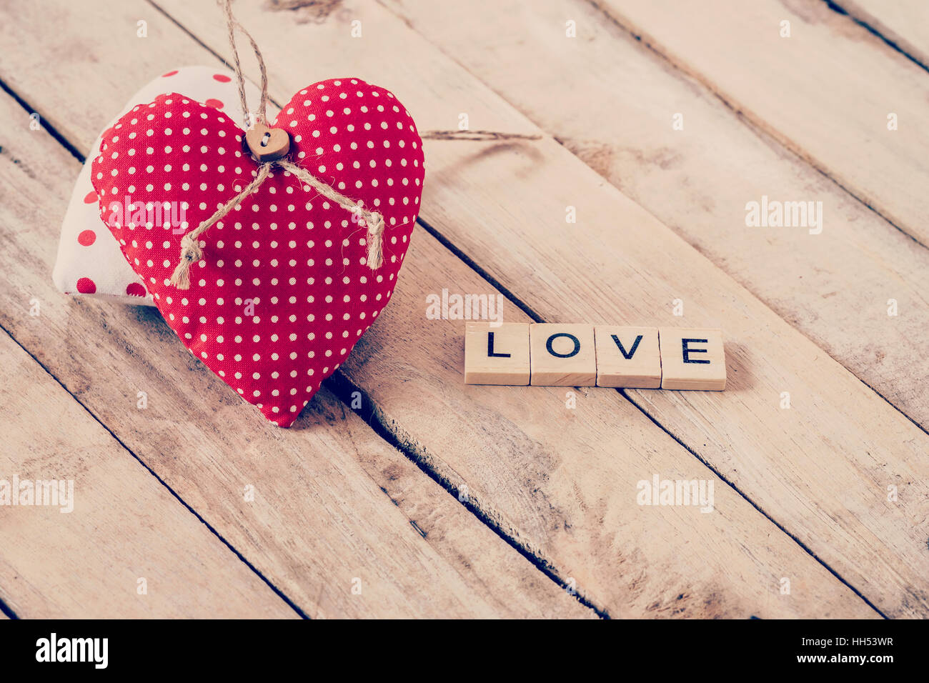Heart fabric and wood text of LOVE on wooden table background. Stock Photo