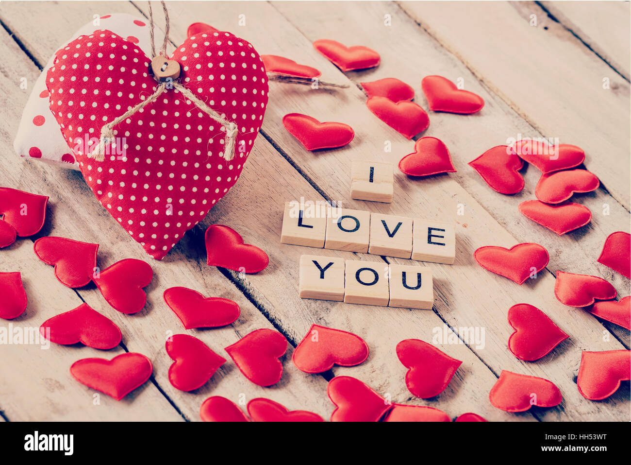 Red heart fabric and wood text of I LOVE You on wooden table background. Stock Photo