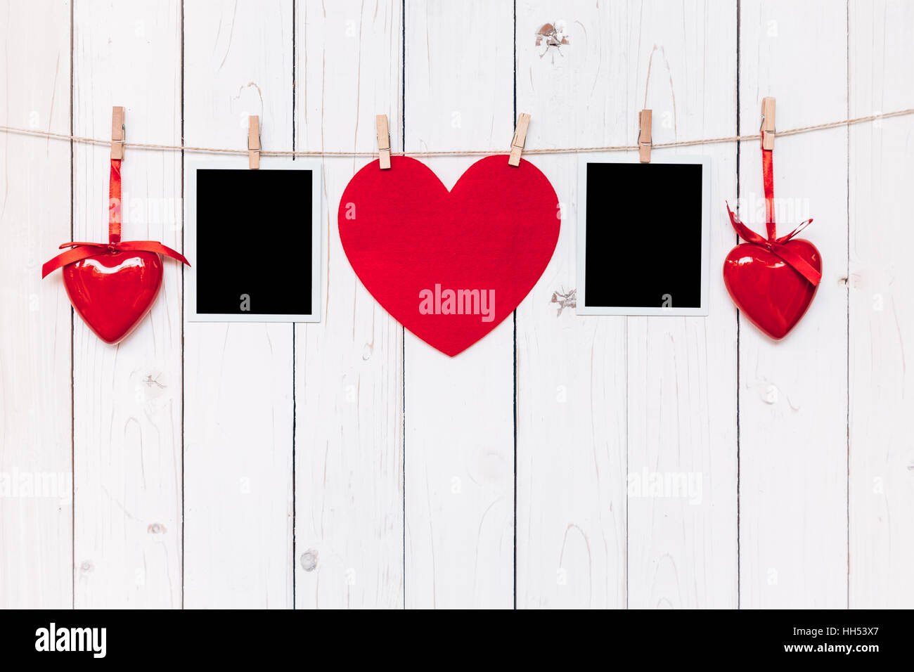 Two photo frame blank and red heart hanging on white wood background with space Stock Photo