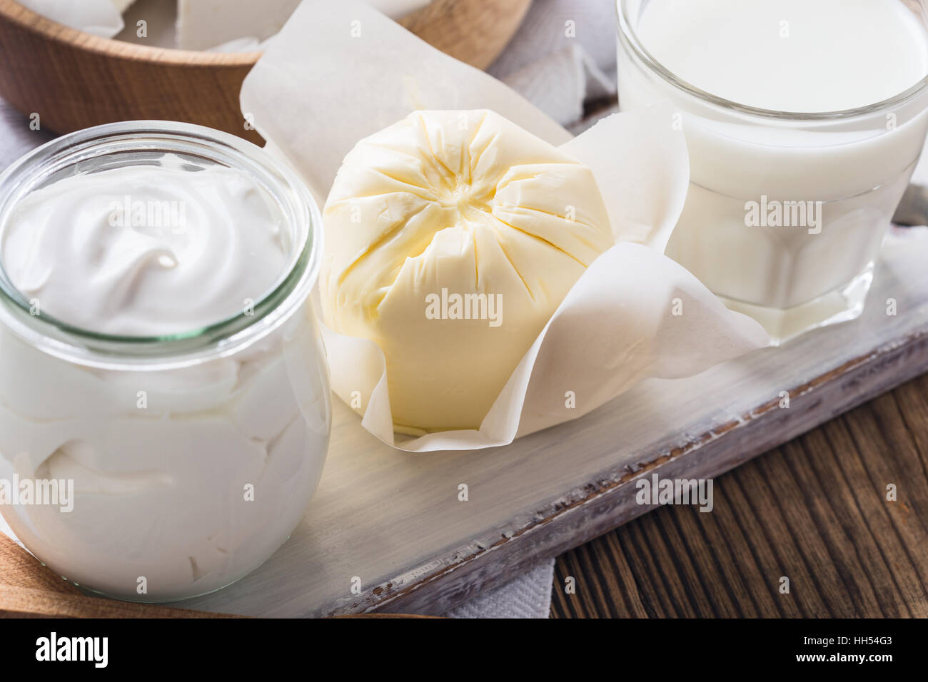 Organic dairy products on rustic wooden table. Milk, butter, sour cream Stock Photo
