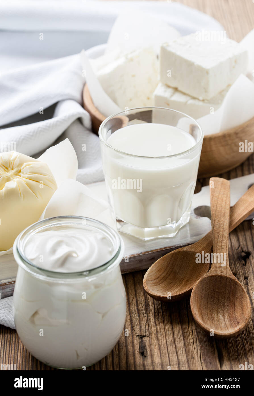 Organic dairy products on rustic wooden table. Cheese, milk, butter, sour cream Stock Photo