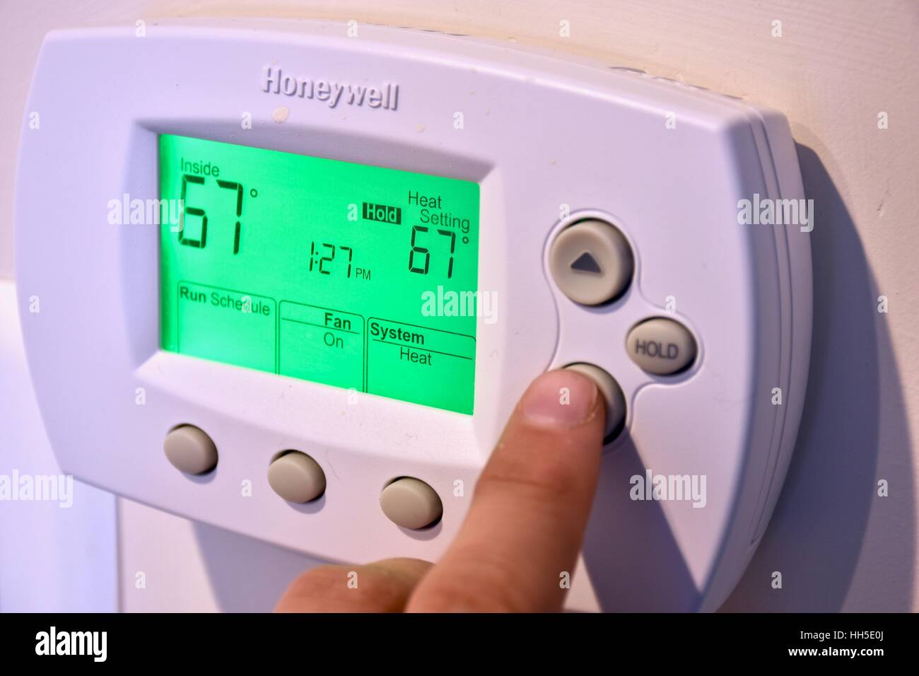 An electronic thermostat on the wall of a residential home Stock Photo