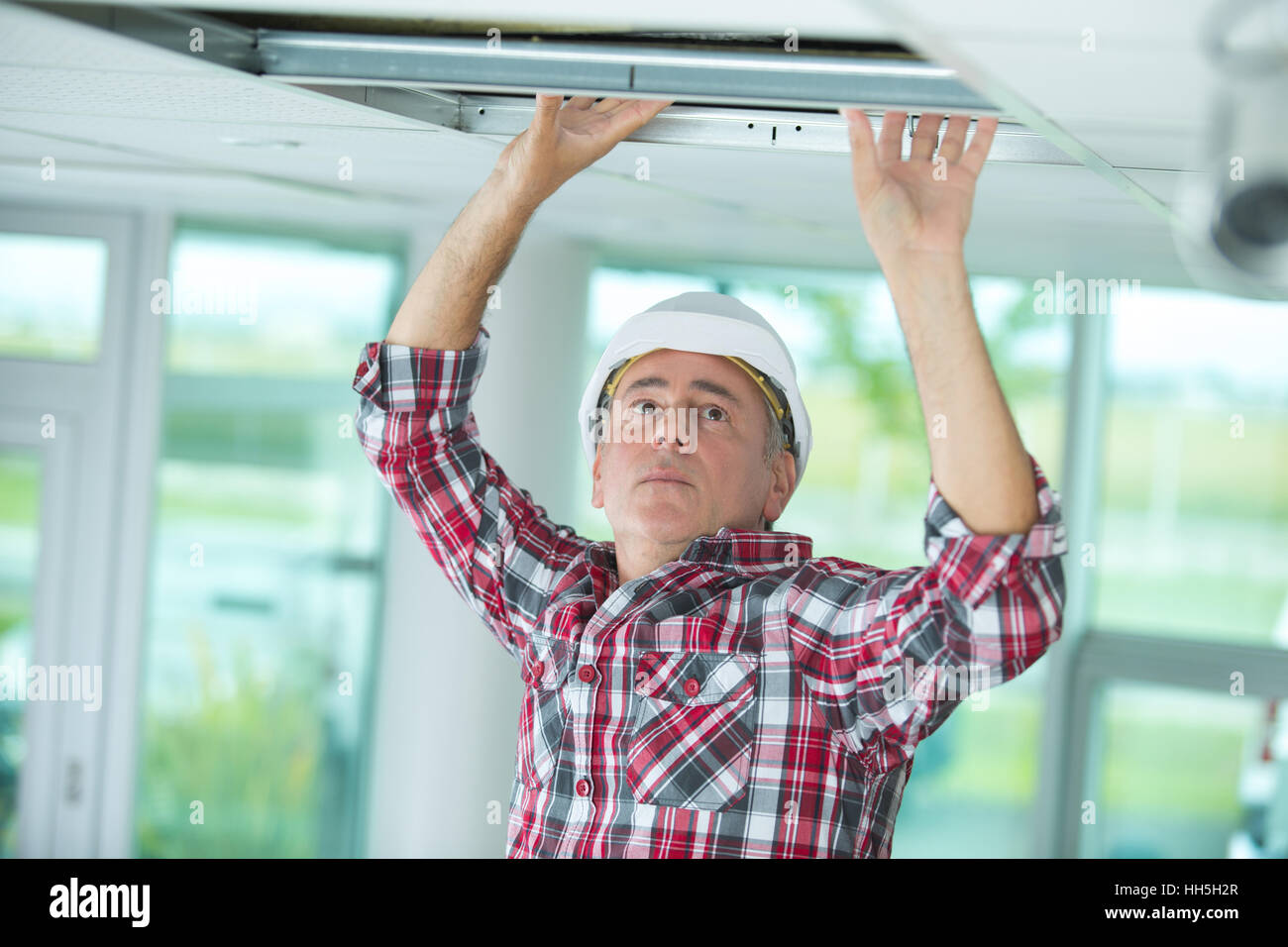 Man installing suspended ceiling Stock Photo - Alamy