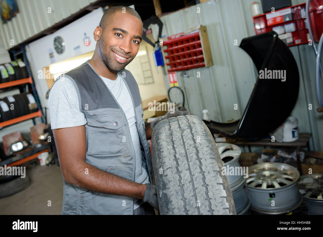 worker holding a tire Stock Photo