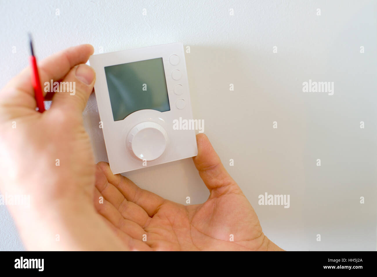 Electrician fitting a new thermostat Stock Photo Alamy