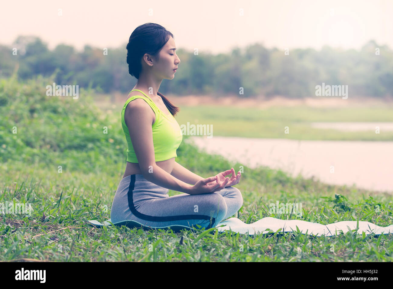 Beautiful Asian women doing yoga in park Stock Photo - Alamy