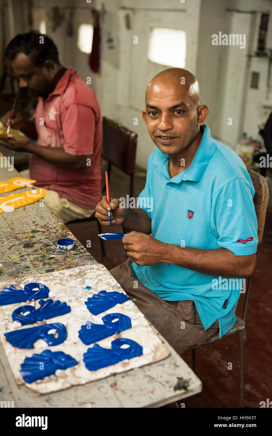 Painter painting masks in shop Ariyapala and Sons Mask museum
