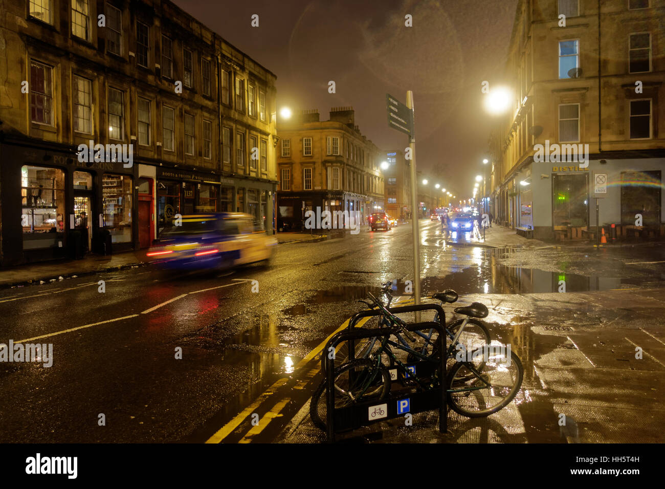 wet rainy night in Finnieston is Scotland's Shoreditch gentrified bad part of town that borders the affluent desirable west end Stock Photo