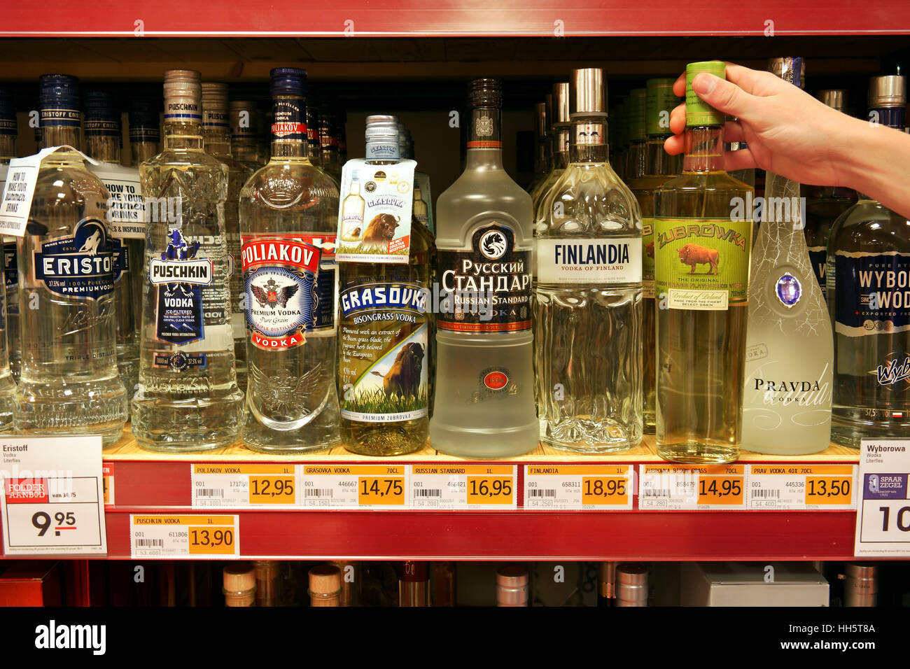 A customer picks a bottle of vodka at a shop Stock Photo