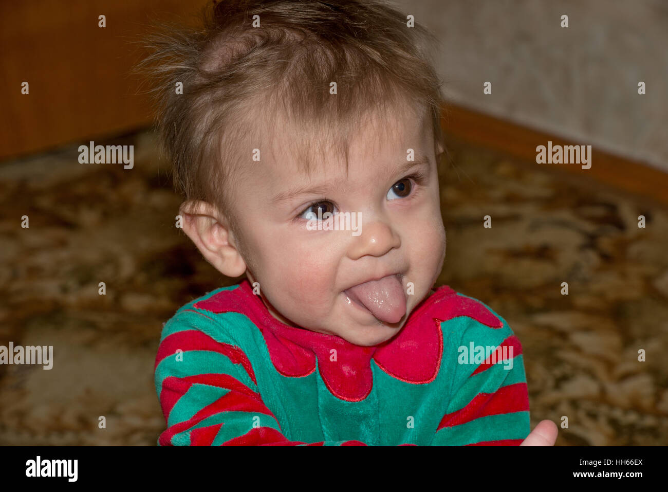 Closeup head and shoulders portrait of little baby boy in redgreen