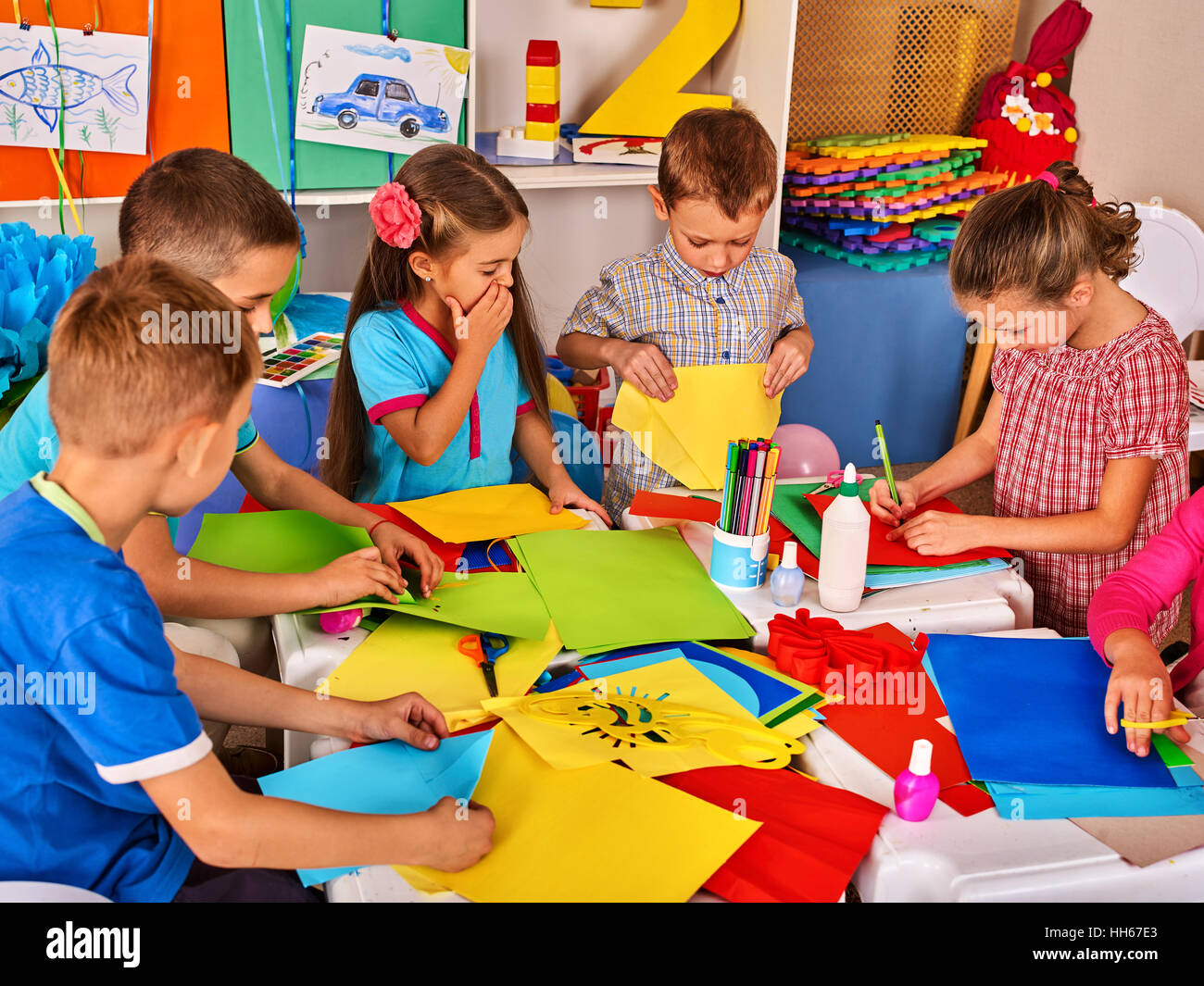 Child cutting paper in class. Development social lerning in school