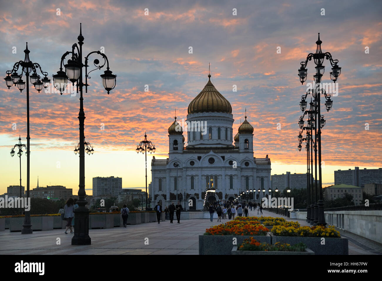 Walking on Patriarchy Bridge in the Sweet Light before Sunset. Cathedral of Christ the Savior in between old-style street lamps Stock Photo