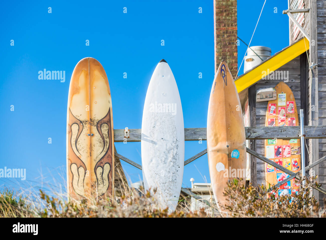 surf boards on display outside with a brilliant blue sky Stock Photo