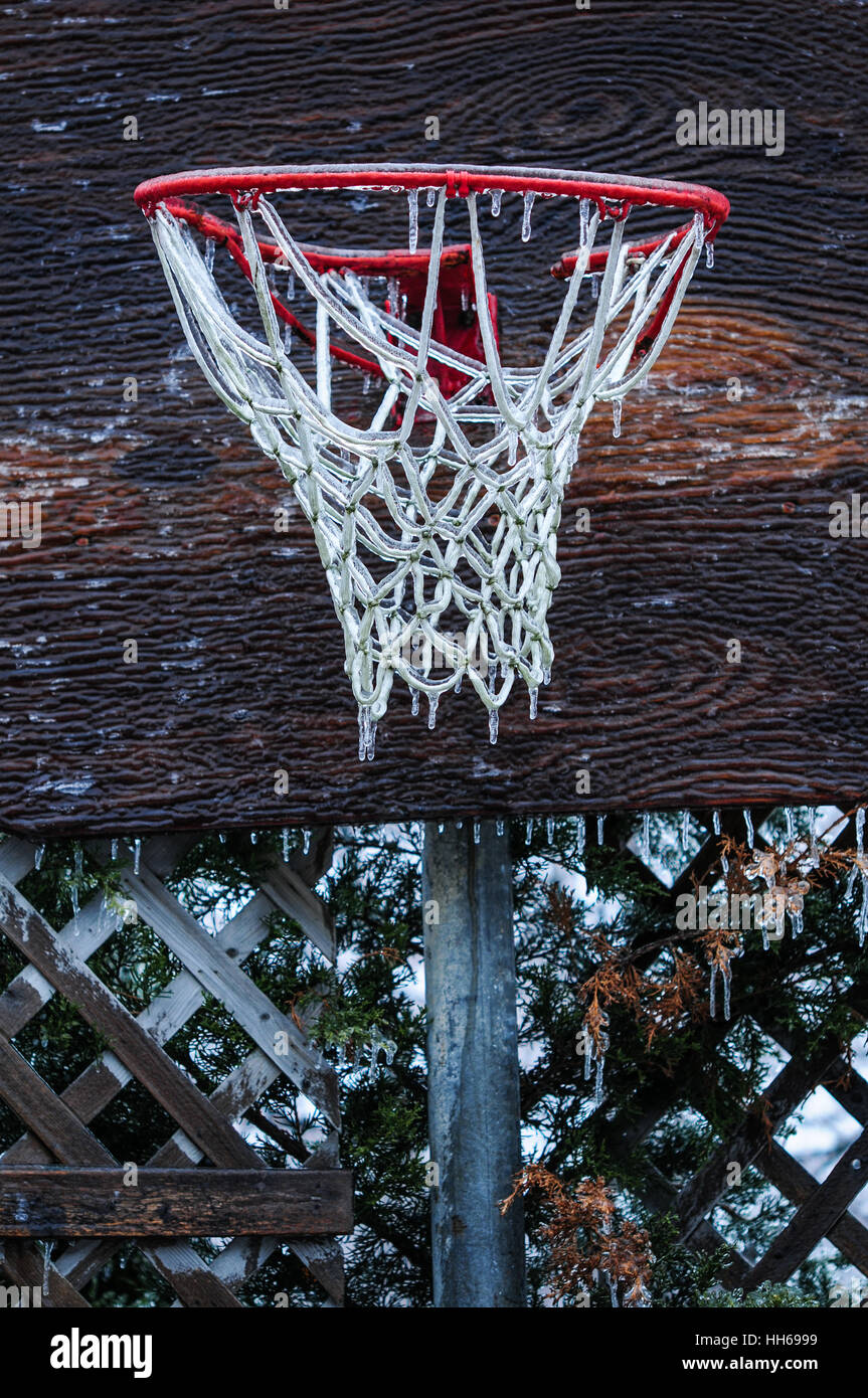 Basketball net encased in ice after a storm. Ice storm in Toronto, frozen  water droplets on surfaces. Icicles on sports court and net Stock Photo -  Alamy