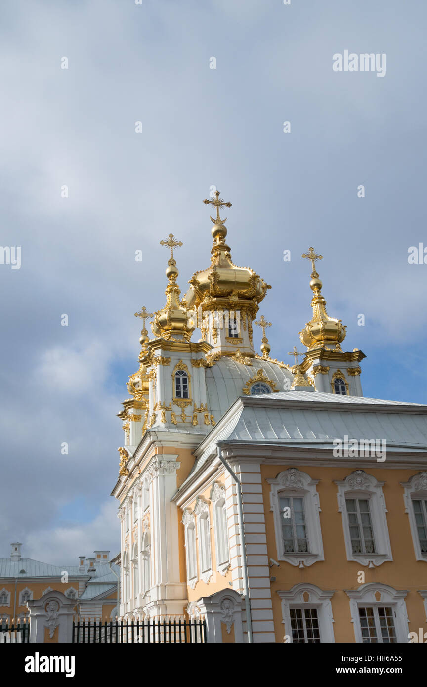 The yellow and white exterior and gold onion domes of the Imperial Chapel at the Peterhof Palace