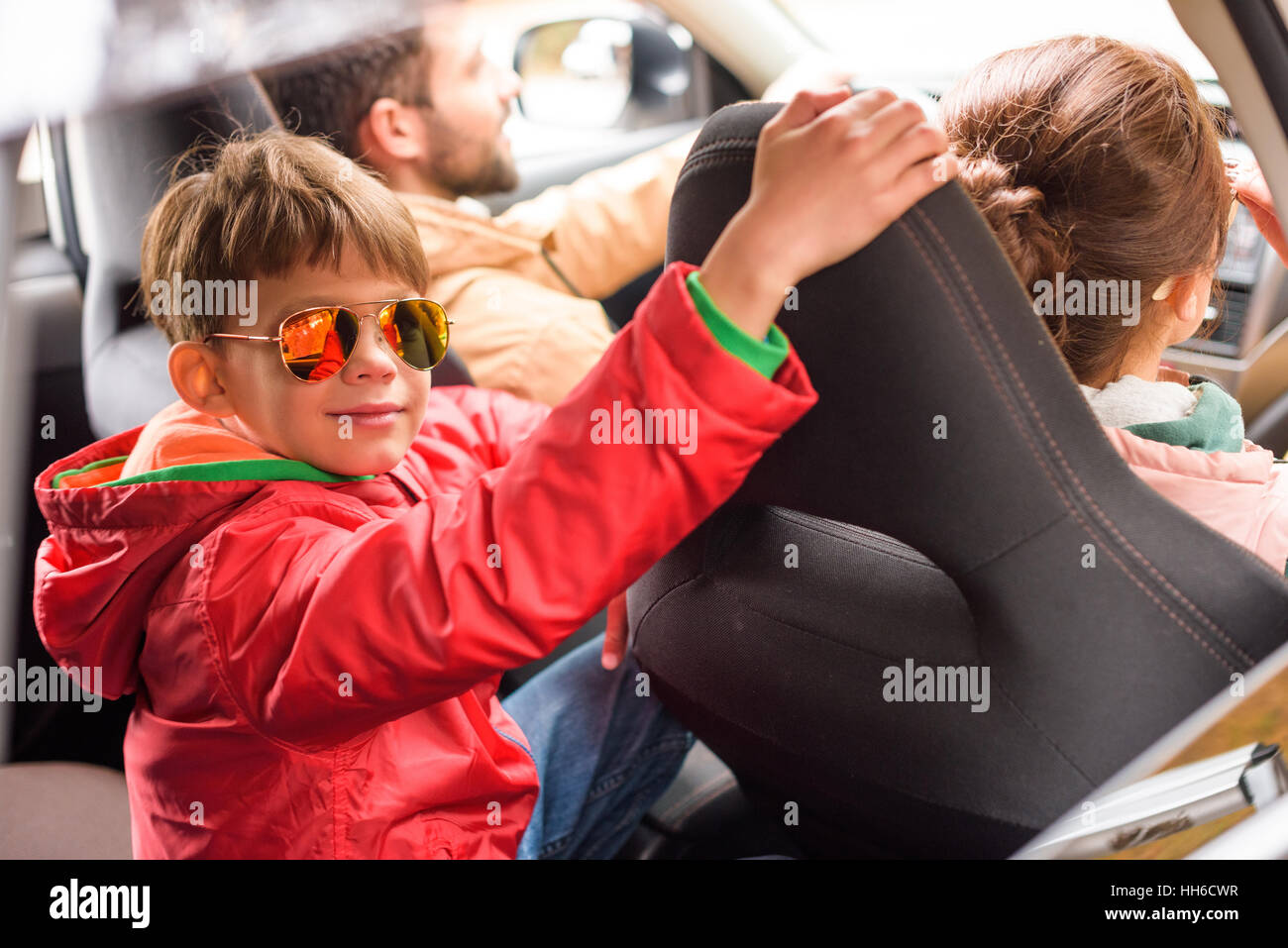 Happy friendly family travelling by car on rural road Stock Photo