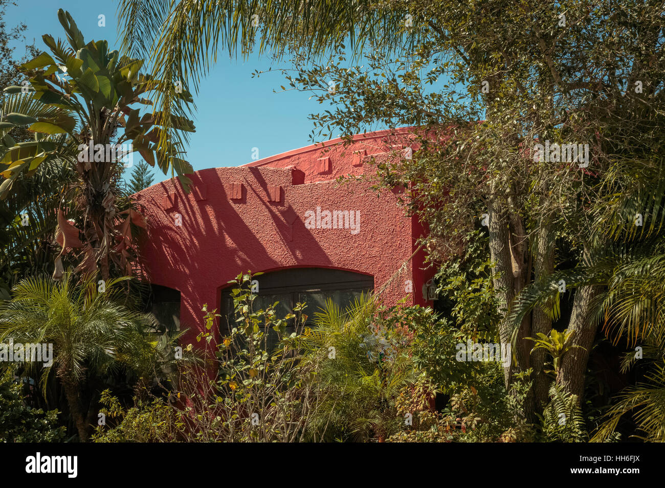 Residence nearly obstructed from view by thick tropical foliage Stock Photo
