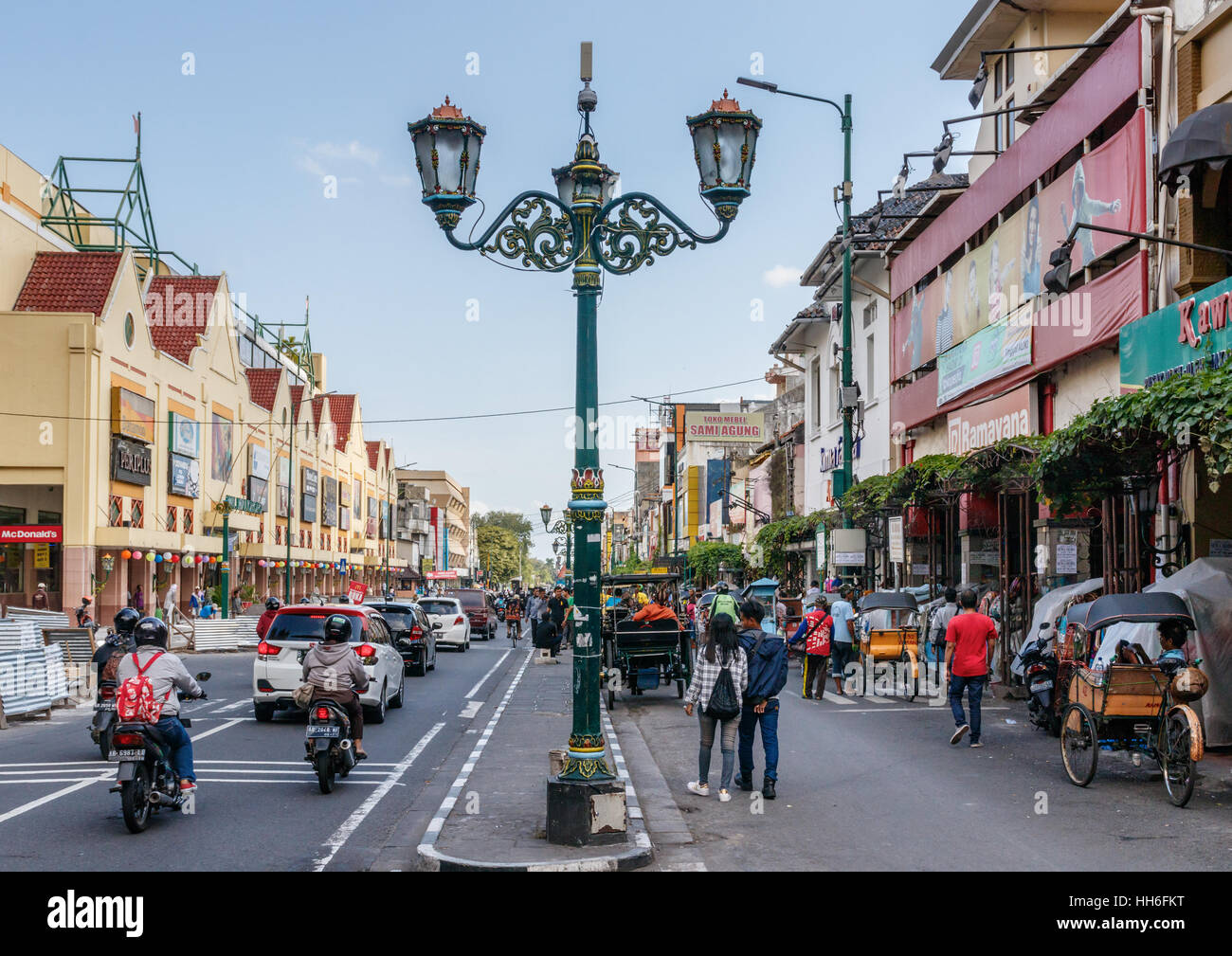 Jalan Malioboro with shops, traffic locals and a characteristic streetlamp, Yogyakarta, Indonesia. Stock Photo