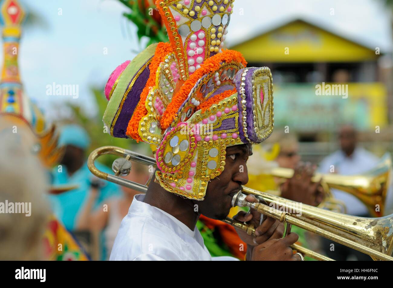 trombone player in carnival dress in a Junkanoo band playing in a street parade on Nassau Bahamas Stock Photo