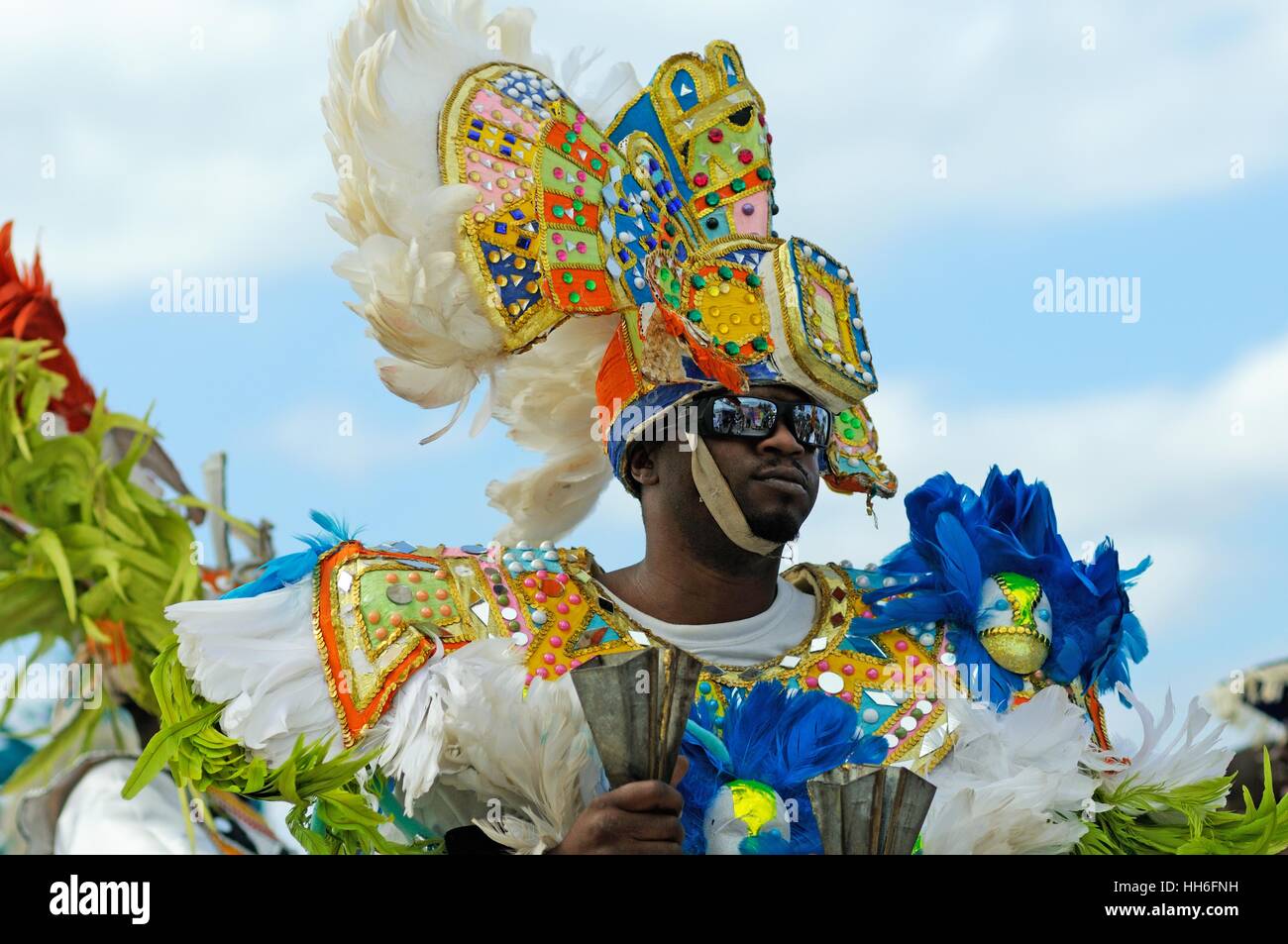 musician in carnival dress in a Junkanoo band playing in a street parade on Nassau Bahamas Stock Photo