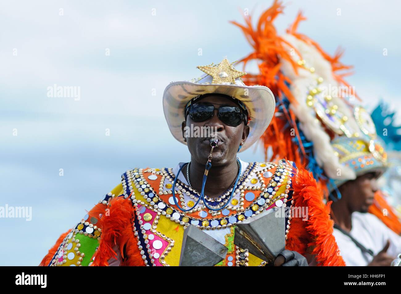 musician in carnival dress in a Junkanoo band playing in a street parade on Nassau Bahamas Stock Photo