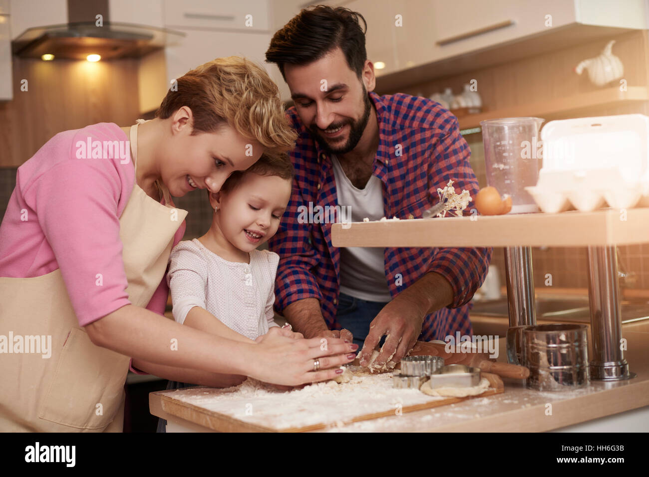 Kid loves spending time with her parents in the kitchen Stock Photo