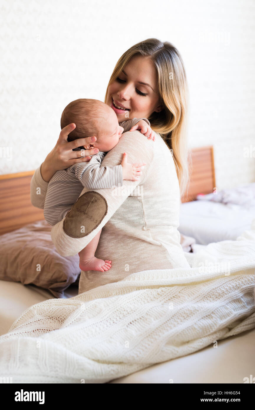 Beautiful young mother holding baby son in her arms Stock Photo