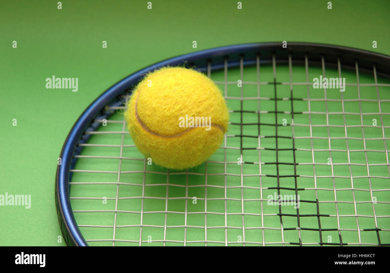 Tennis racket and ball on green background Stock Photo - Alamy