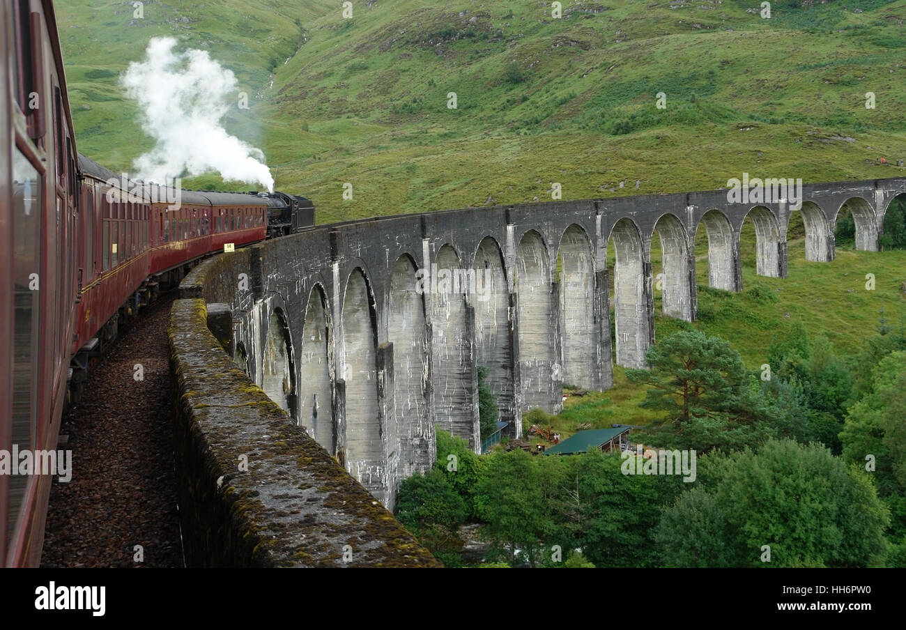 the Glenfinnan Viaduct in Scotland with the Jacobite steam train on it, scenery seen from steam train Stock Photo