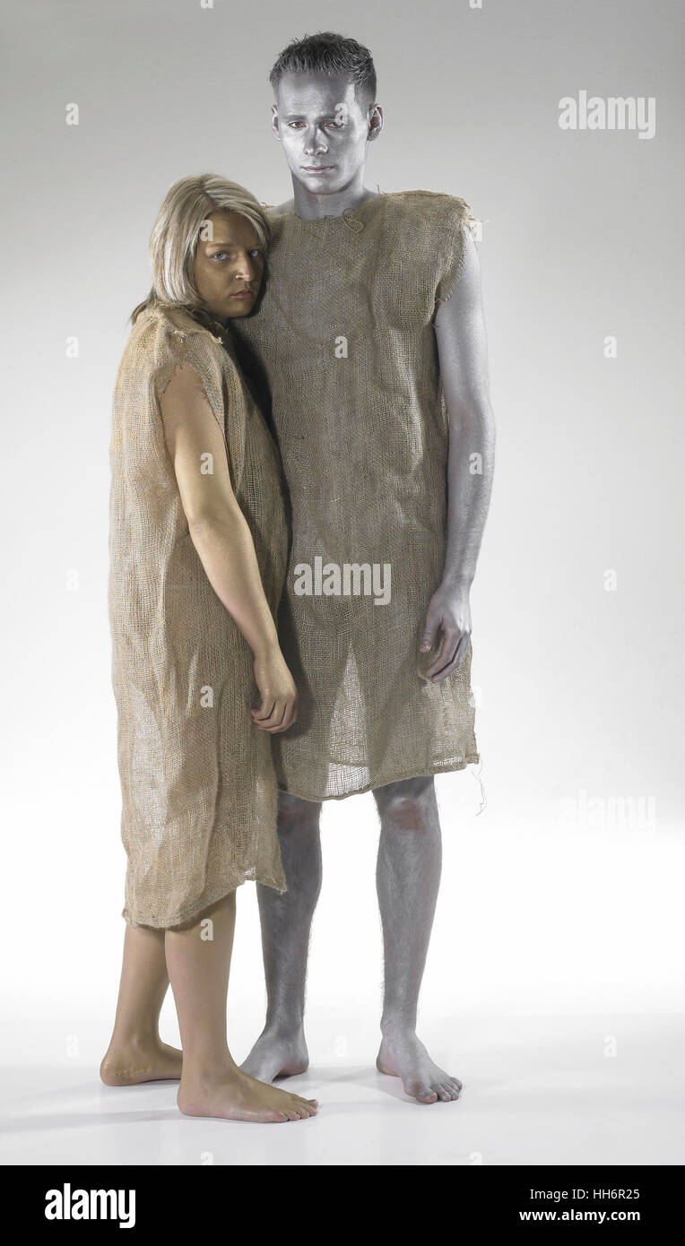 bodypainted young man and woman dressed in gunnysacks. Studio shot in light grey back Stock Photo