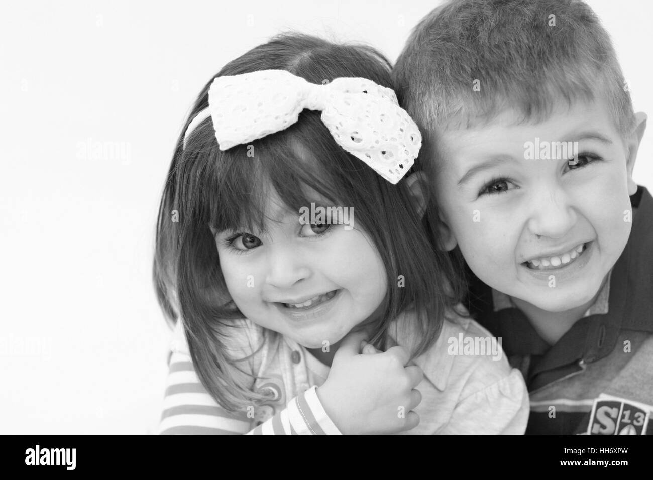 Brother and sister portrait kids children  laughing playing together boy girl large boy pretty innocent concept childhood concept family black white Stock Photo