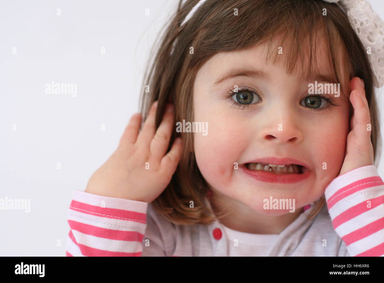 Little girl, child making a funny angry face, grinding / clenching her teeth kids faces, grimacing, innocent concept Stock Photo