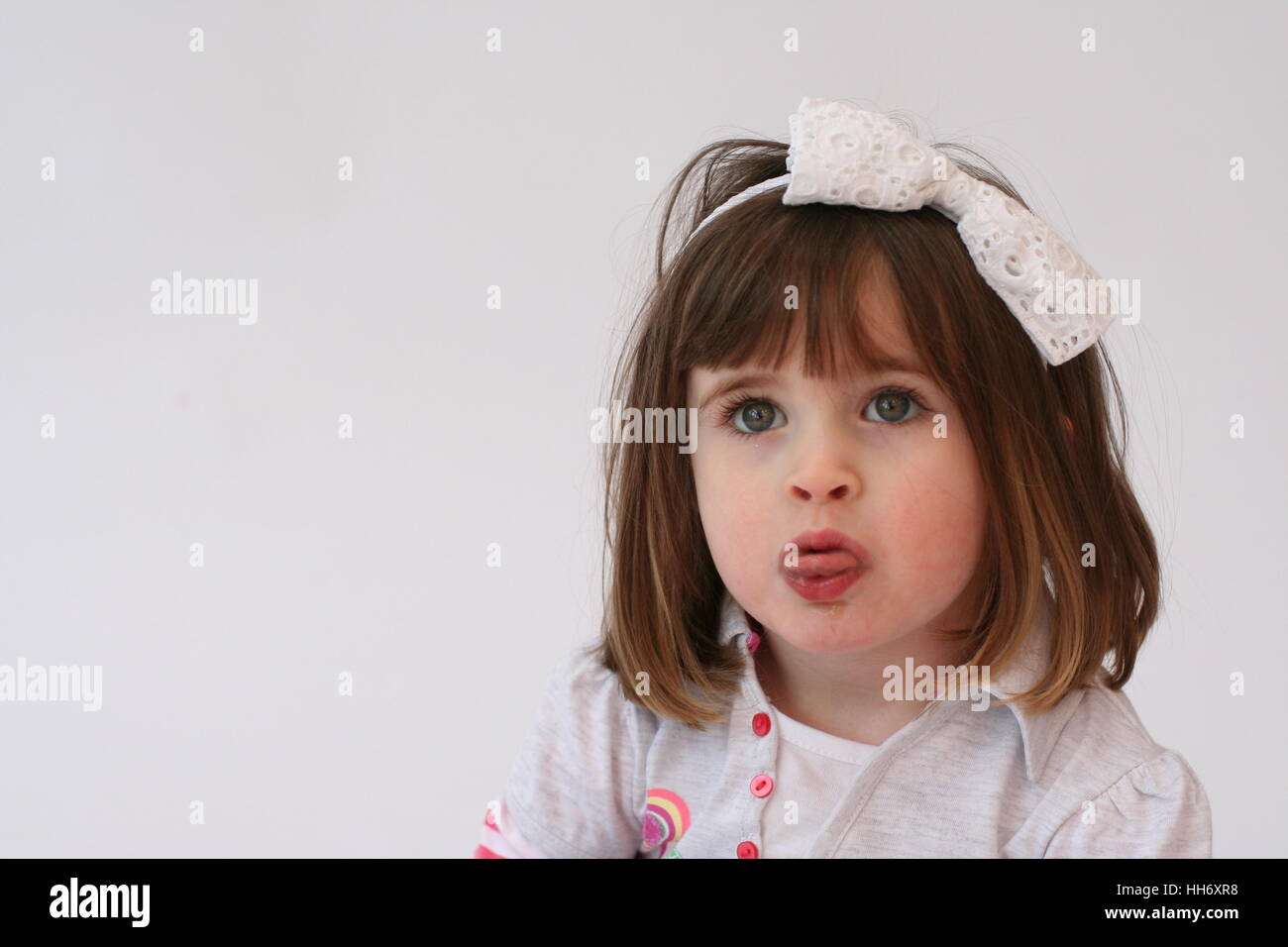 Little girl, 3 year old child making a funny angry face,sticking tongue out  kids faces, grimacing, innocent concept messy hair, childhood concept Stock  Photo - Alamy
