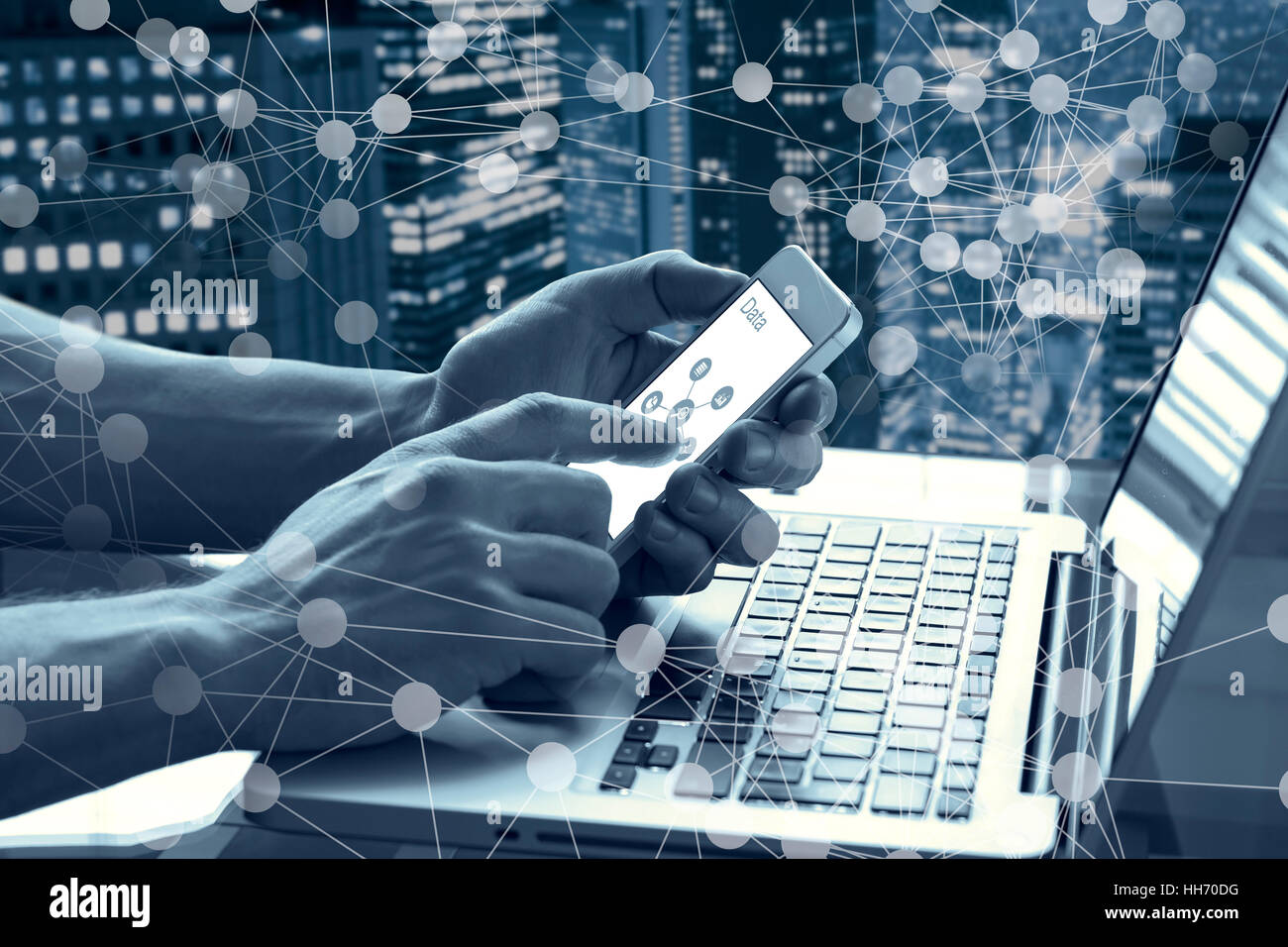 Data and modern technology concept with a person touching a mobile phone screen and using a computer with abstract network diagram Stock Photo