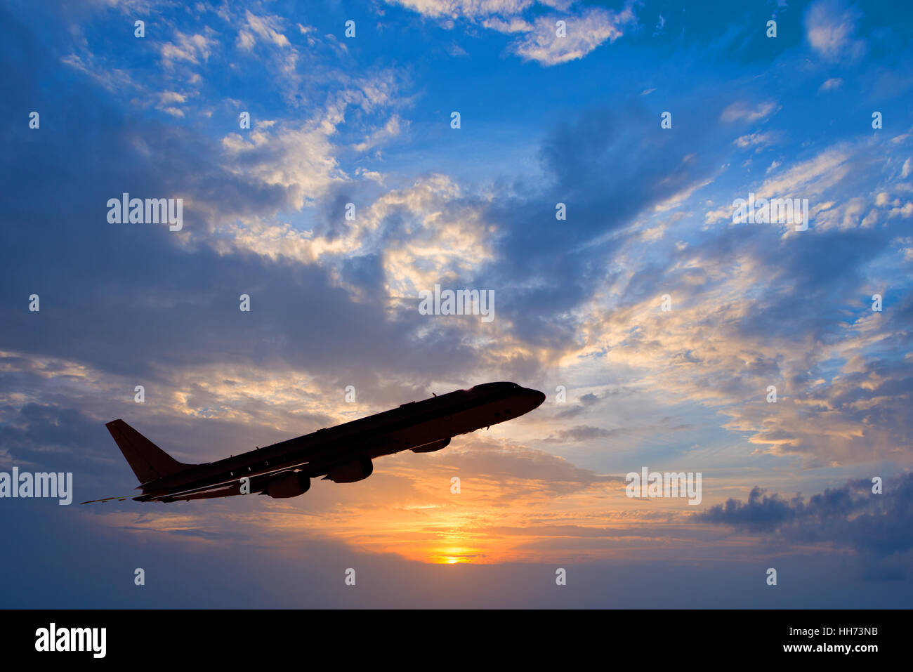 Silhouette of an airplane taking off, sunset background Stock Photo
