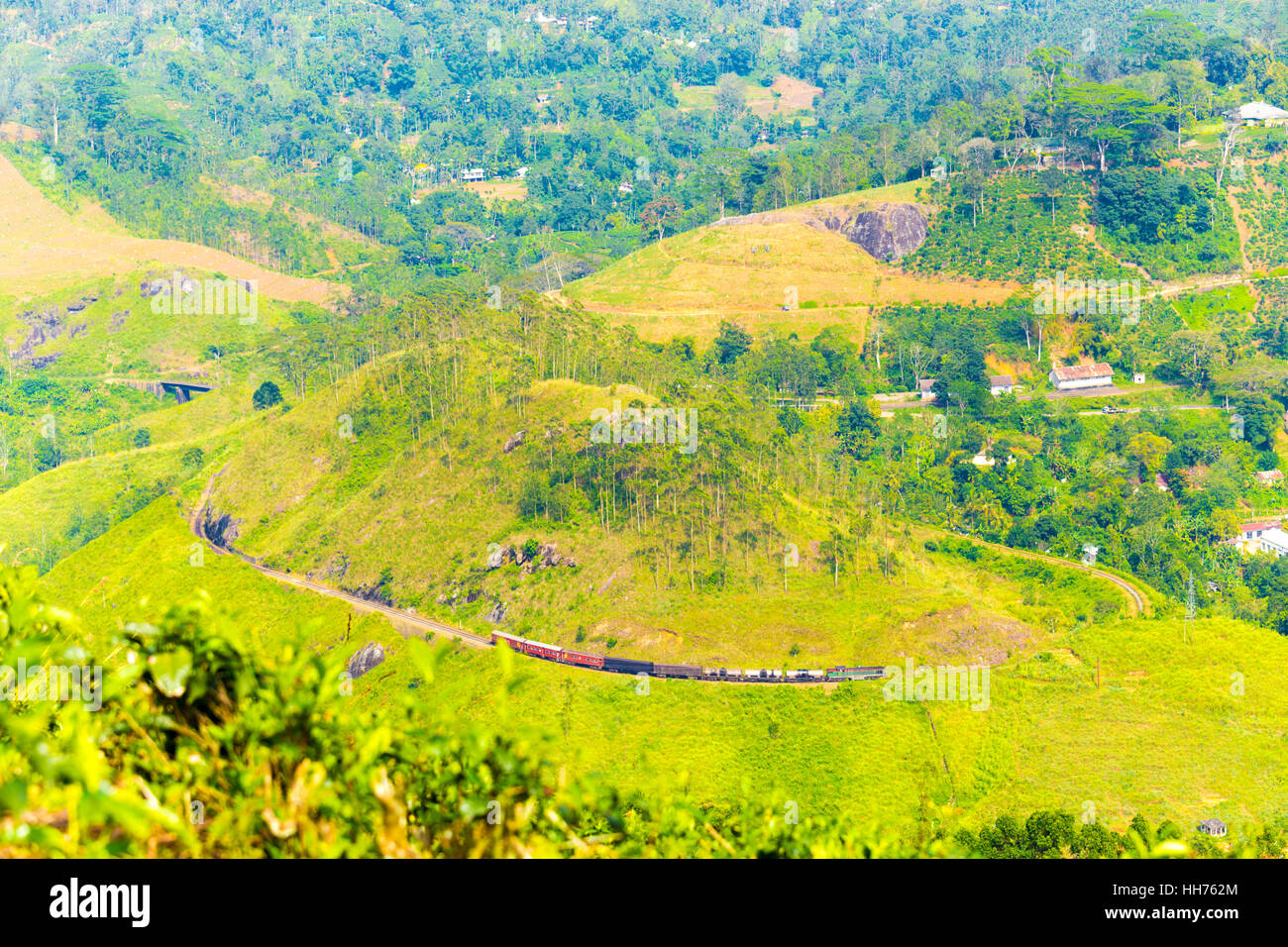 High angle aerial view of train moving along distant Demodara Loop, a spiral portion of circular track to gain elevation Stock Photo