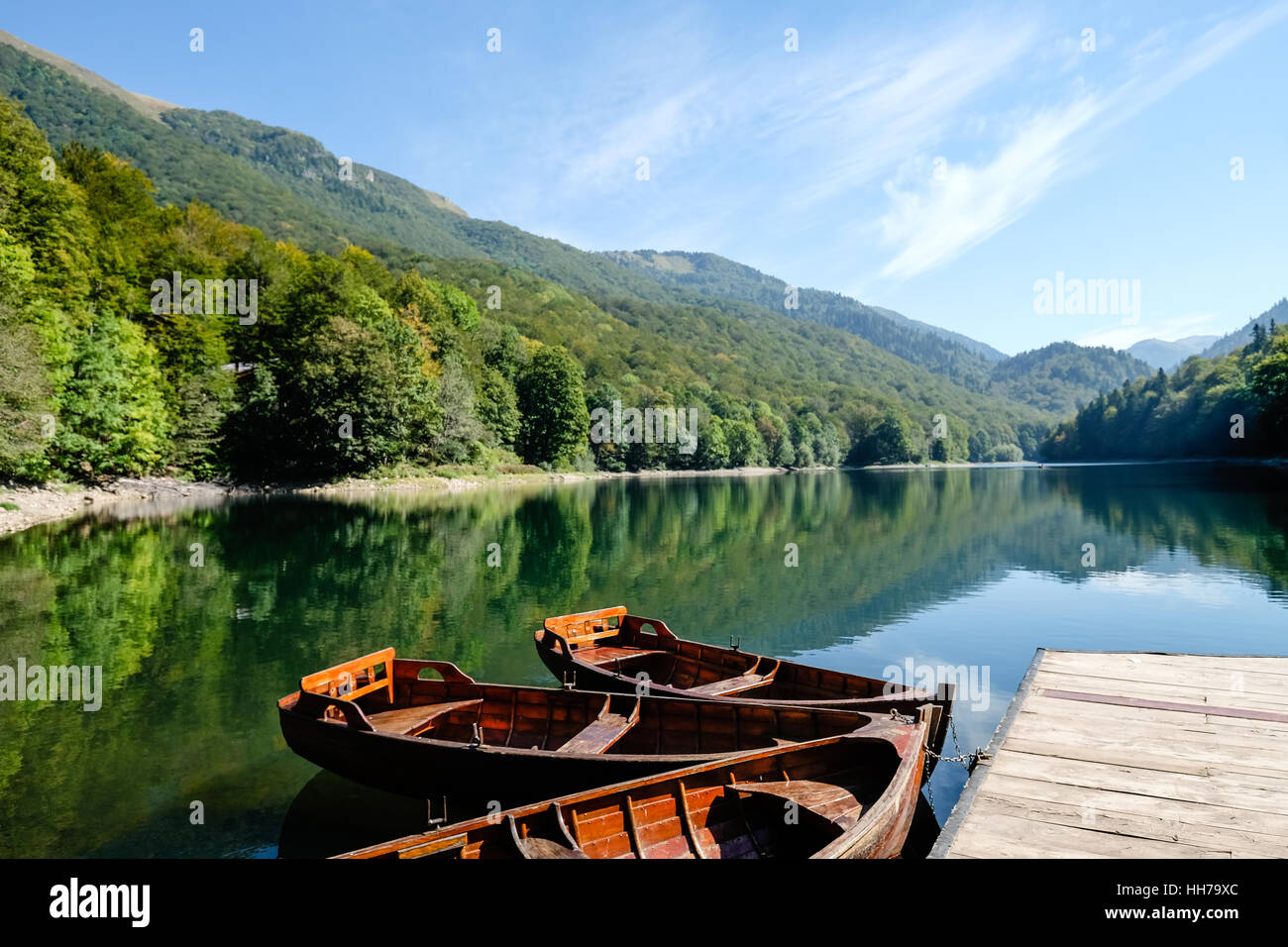 Boats tied to pontoon on lake in Montenegro Stock Photo