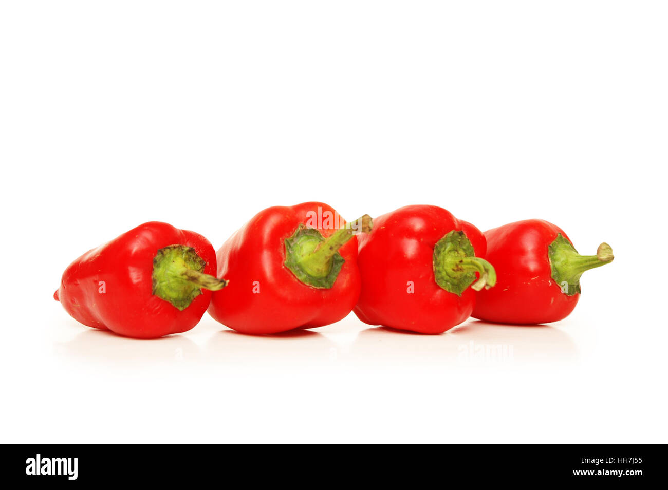 Four red chili peppers isolated on white Stock Photo - Alamy