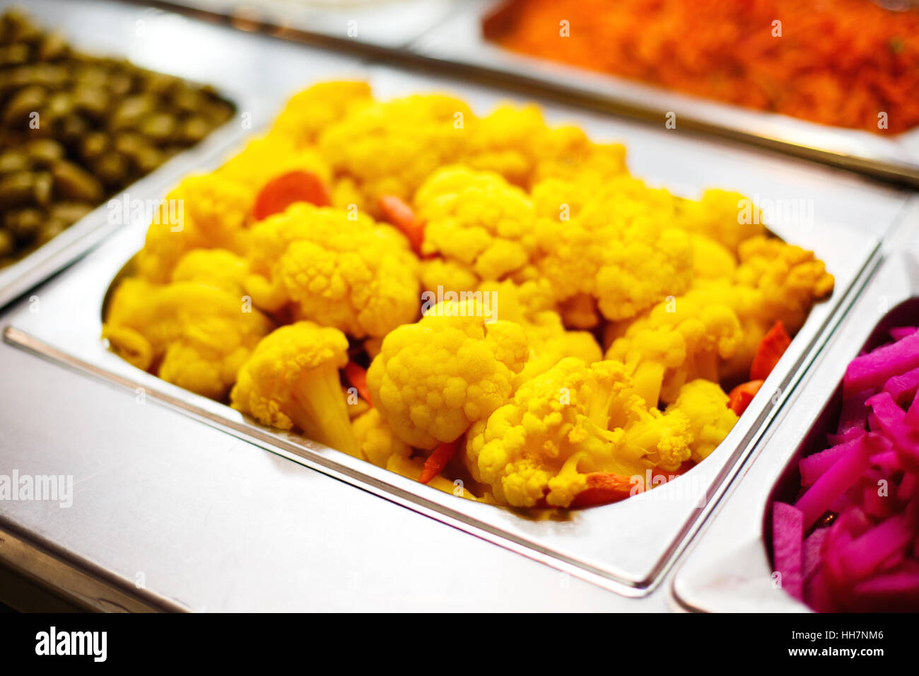 Cooked color yellow cauliflower in metallic dish. Street healthy food. Stock Photo