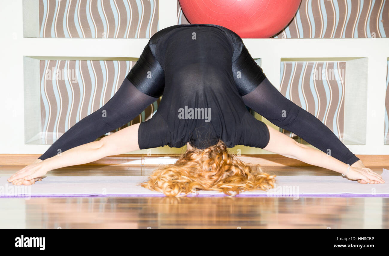 Woman doing yoga exercises and pilates poses on mat on white background ...