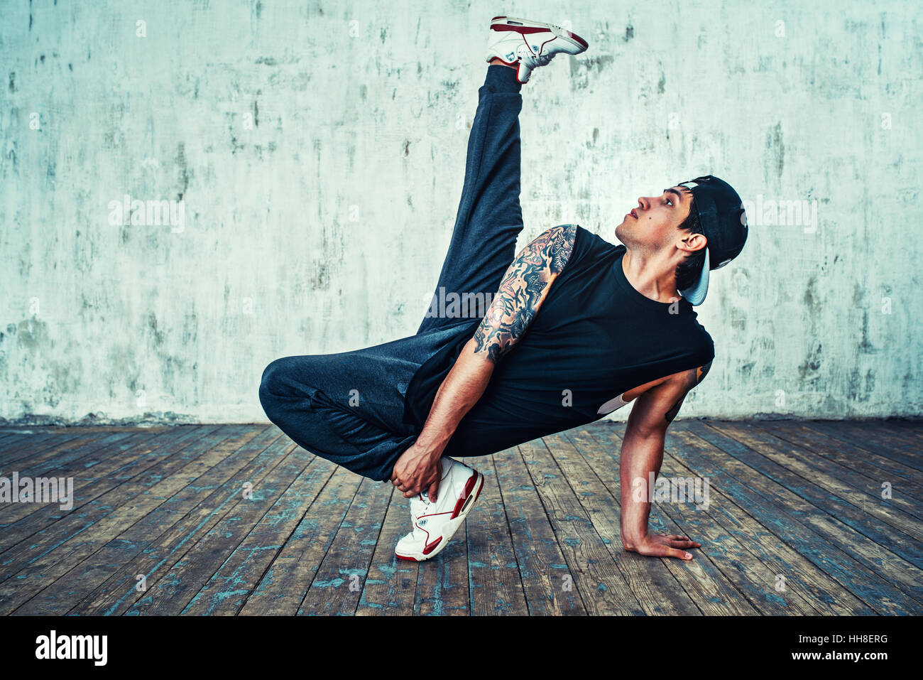 Young man break dancing on wall background. Tattoo on body Stock Photo -  Alamy