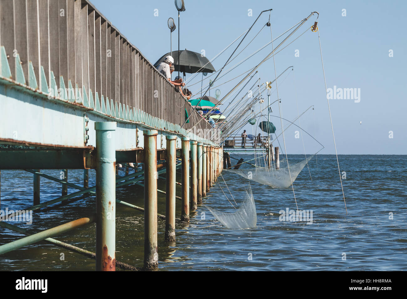 Fishing from the pier or fishing wharf with fishing net and rod at